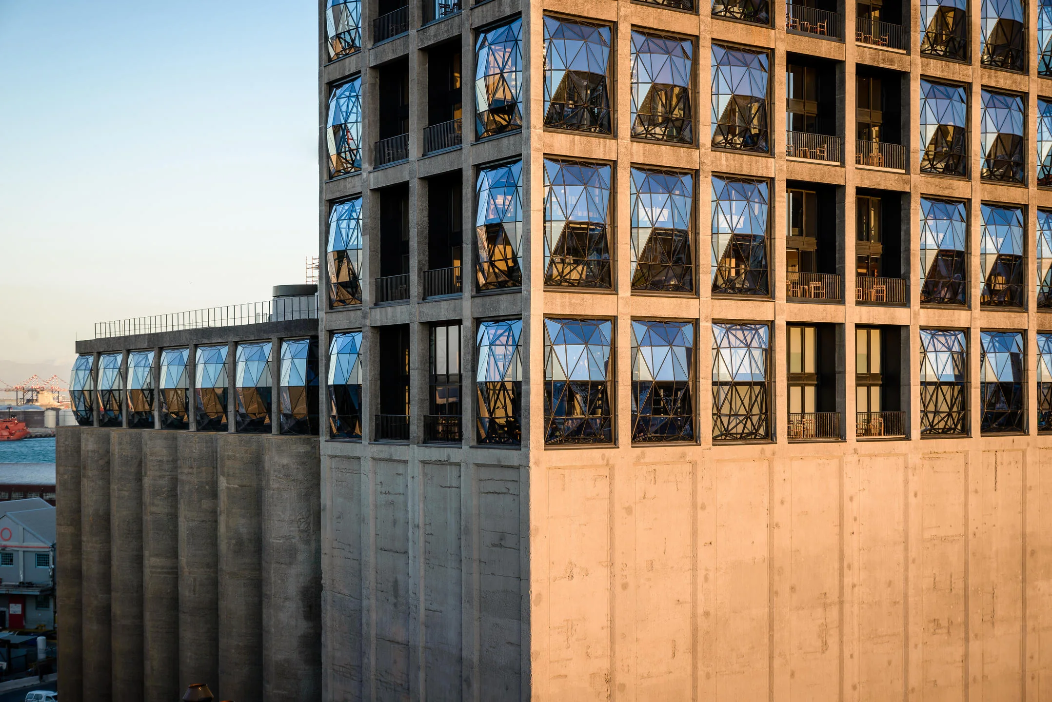 Faceted windows and the historic silo structure in warm evening light