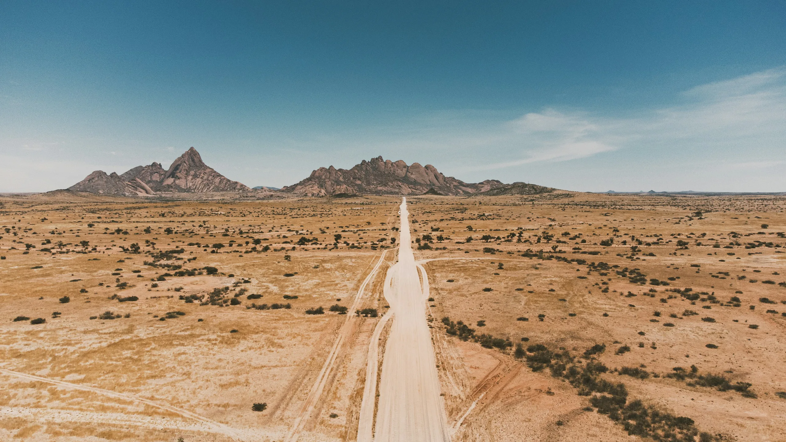 A road crossing the Namibian landscape towards the Spitzkoppe mountains